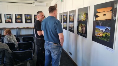 Účastníci vernisáže obdivují vystavené fotografie