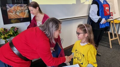 Radní paní Hana Balcarová předává  pasované malé čtenářce taštičku s drobnými dárky