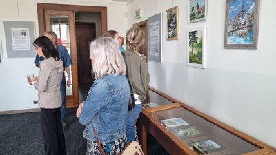 Účastníci vernisáže si prohlíží obrázky J. Pinkavy